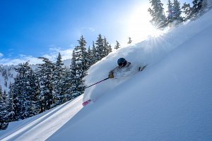 skiing powder under blue sky